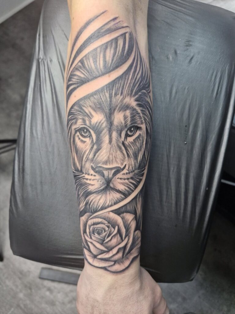 Tattoo von Rummel Art Verden – Realistic Loewe mit Rose – Unterarm