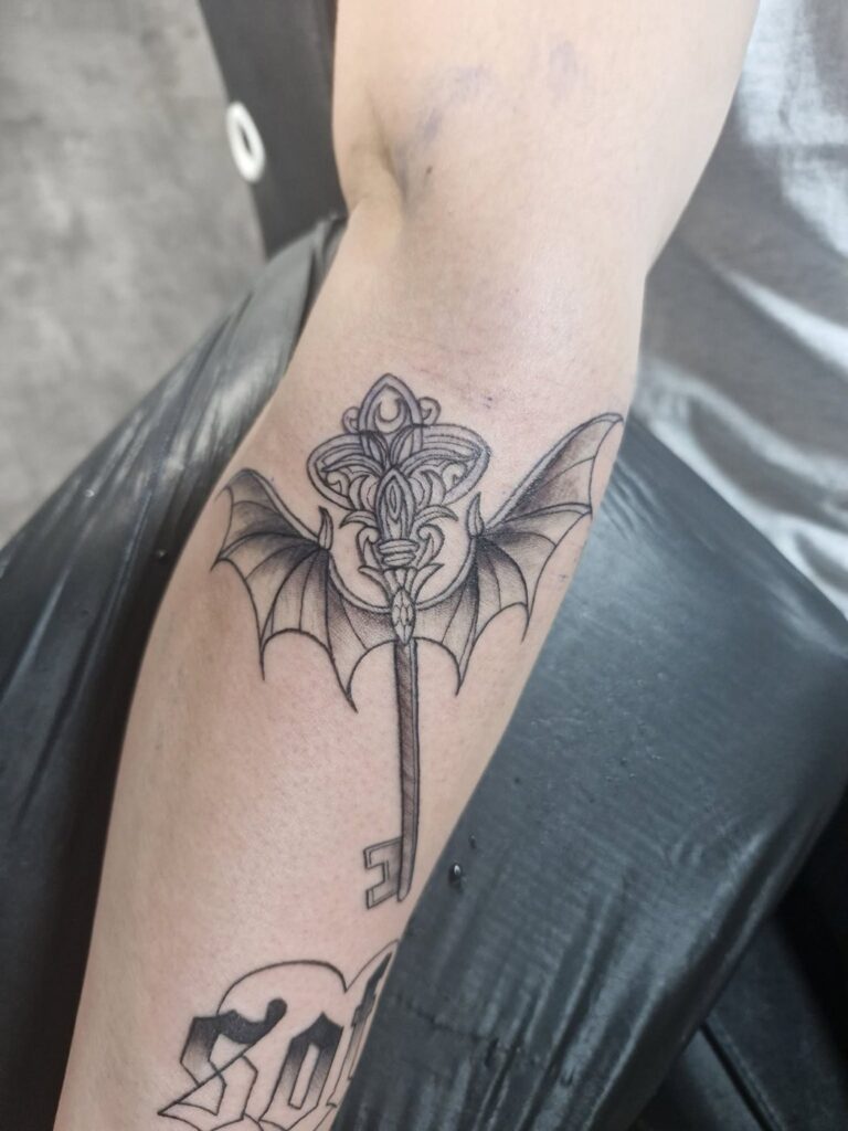 Tattoo von Rummel Art Verden – Black & Grey Fledermaus-Dolch – Arm