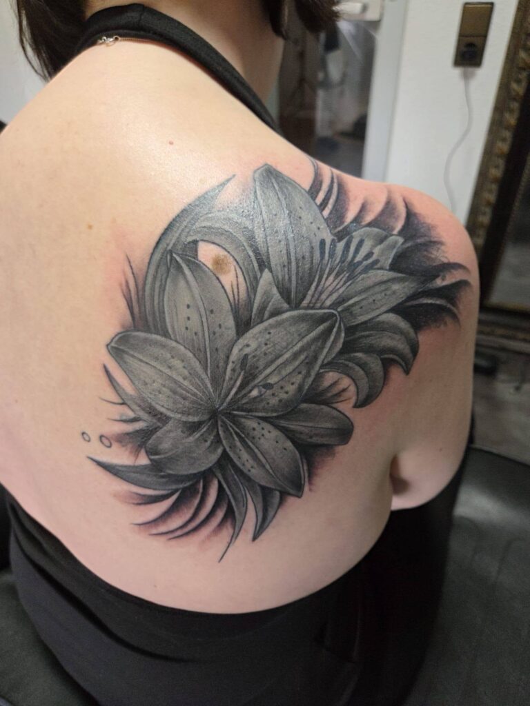 Cover-Up Vorher/Nachher – altes Uhr- und Rosen-Motiv überdeckt mit einer Lilie in Black & Grey, Rummel Art Verden (Aller) – nachher
